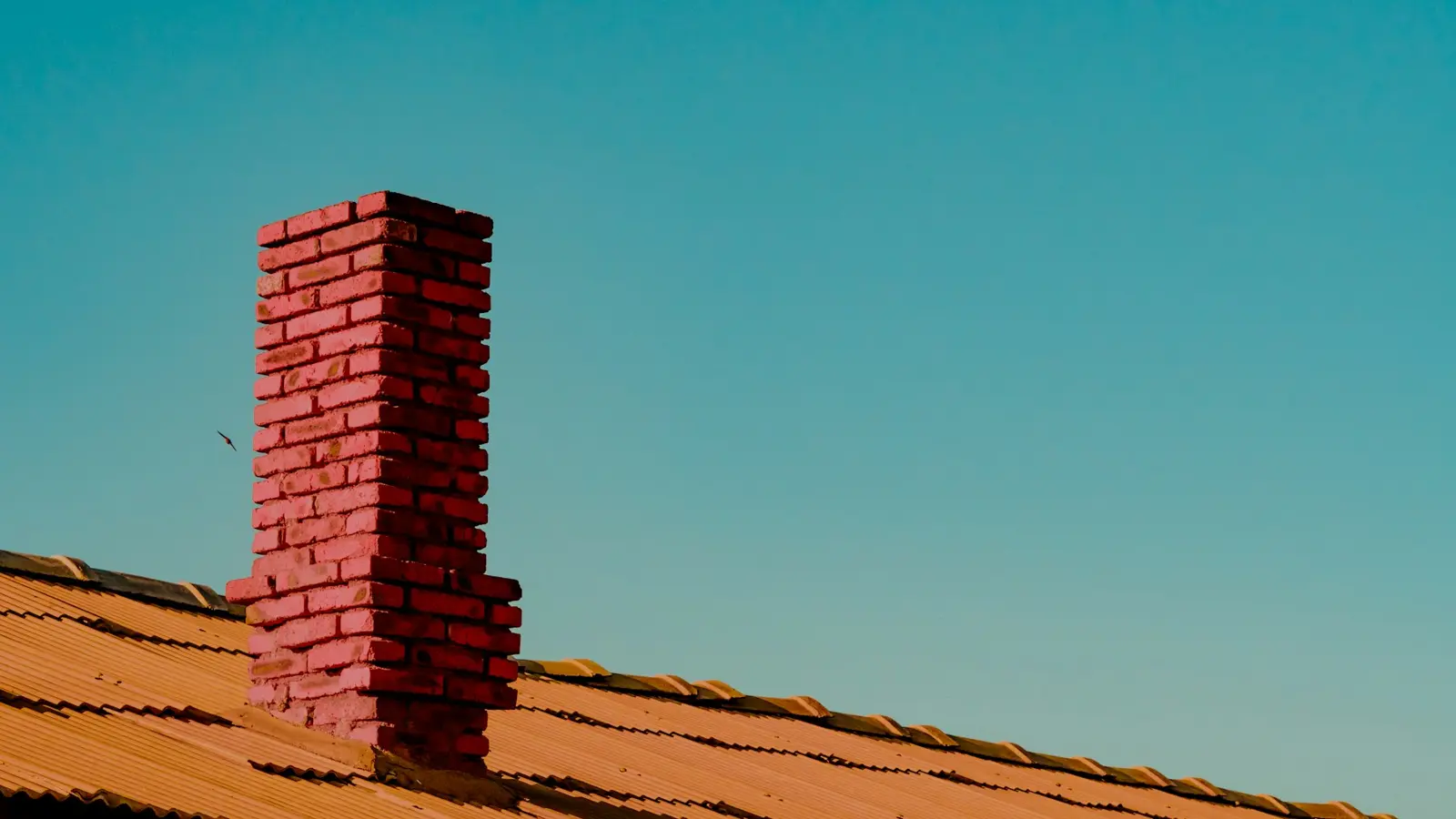 Brick chimney on a clay tile roof