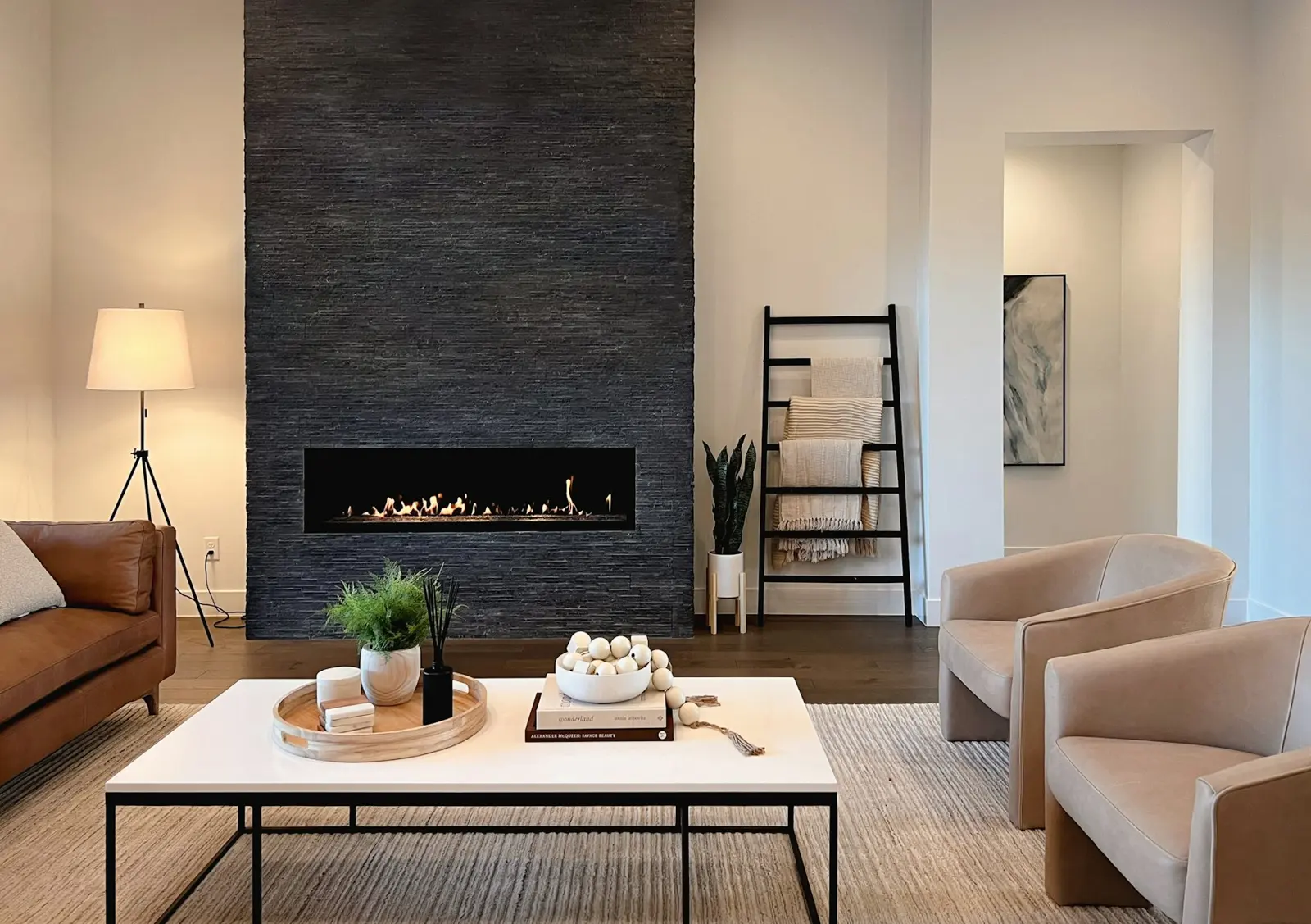 Bright living room with a linear gas fireplace in a stone wall