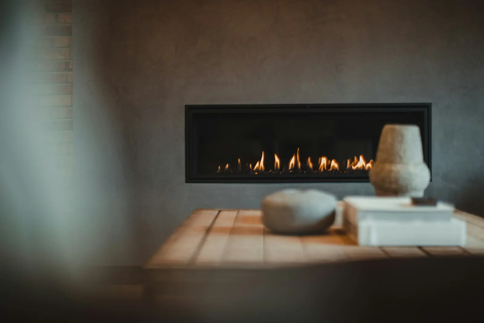 Linear gas fireplace with a low flame in a modern room
