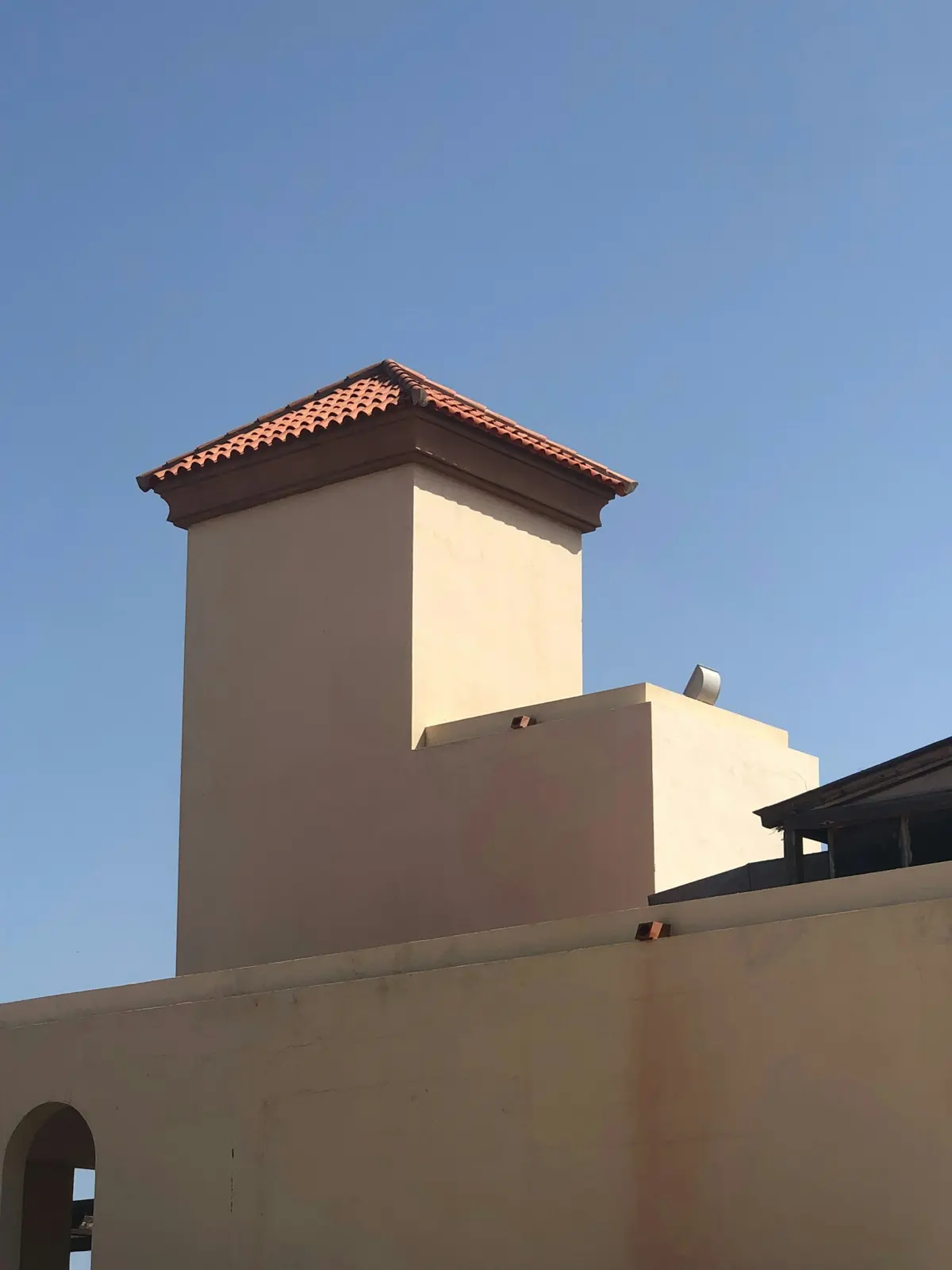Stucco chimney with a tile cap on a desert home