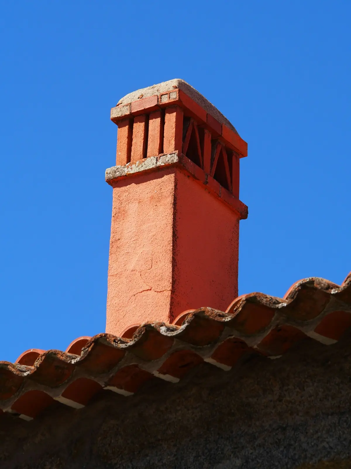 Stucco chimney on a clay tile roof